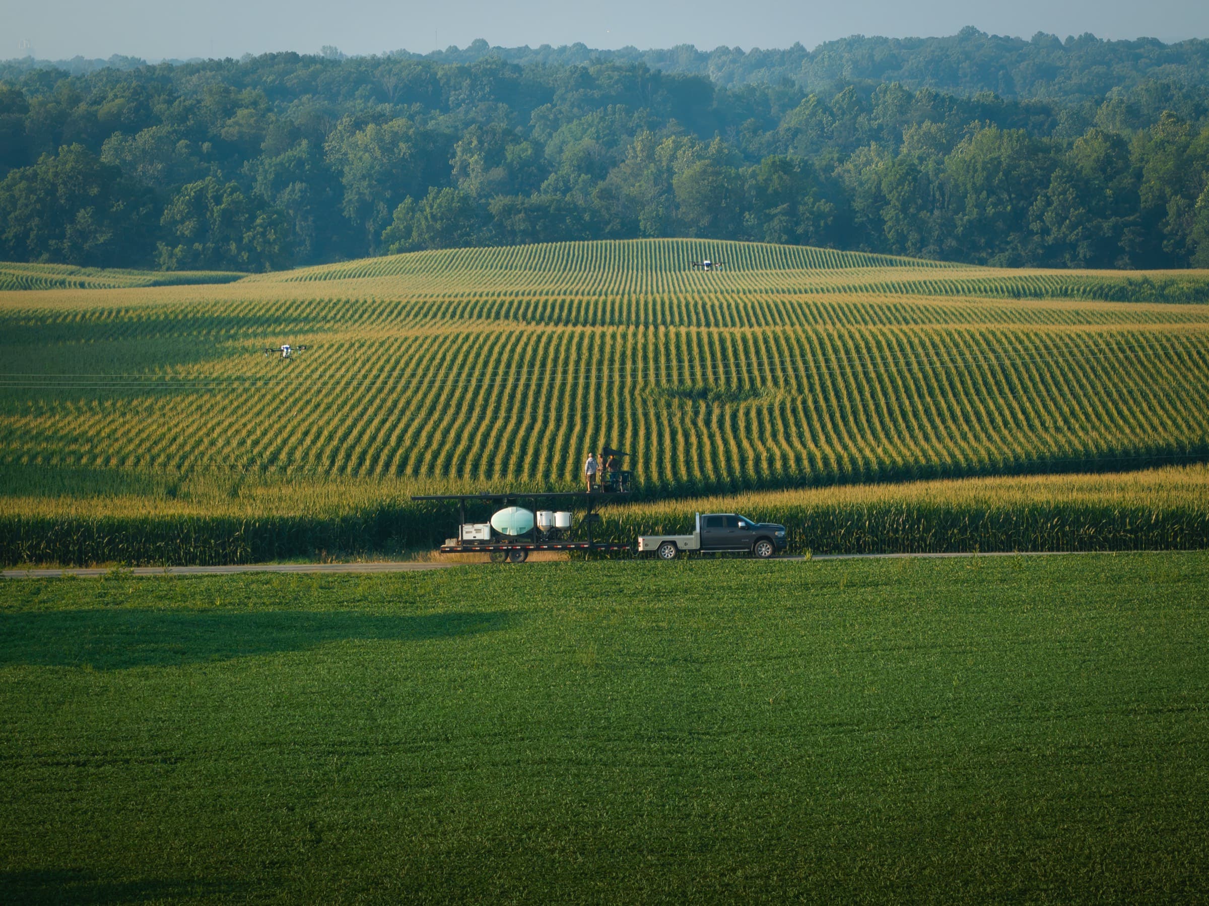 A drone tender setup parked at the edge of a corn field in central Indiana, drone in flight just beyond